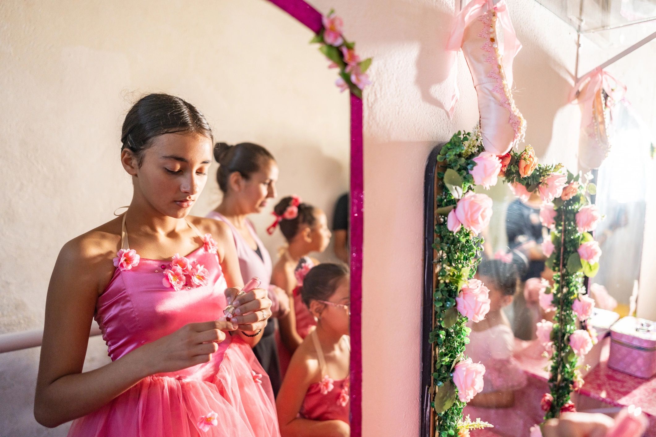Young dancers applying makeup backstage before a performance